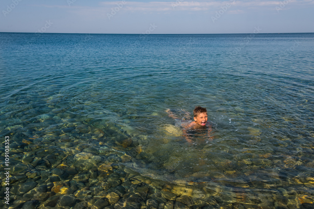 The child learns to swim at the sea