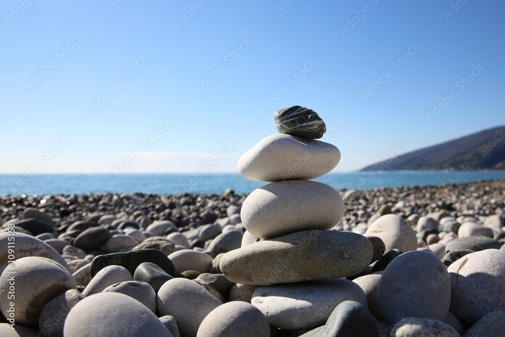 Naklejka Balansuj kamyki na plaży. Harmonia, praca zespołowa lub medytacja.