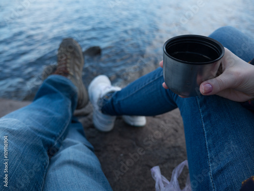 on the beach with thermos and tea, couple, feet, from the first person