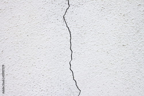 White wall with cracks in the middle, Split down the middle.