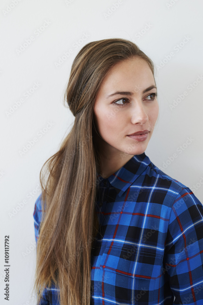 Beautiful young woman in blue shirt, looking away Beautiful young woman in blue shirt, looking away
