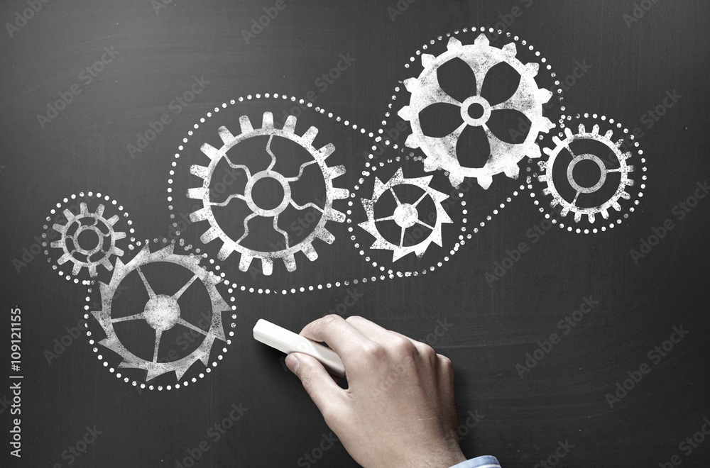 Man drawing gears on blackboard Man drawing gears on blackboard