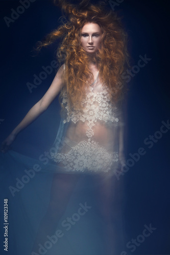 Beautiful fashionable red-haired girl in  transparent dress,  mermaid image with creative hairstyle curls. Fashion beauty style.