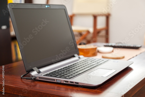Laptop on wooden table in home - enhanced colors