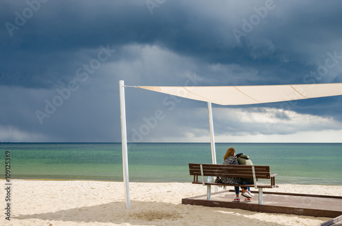 zakochana para na plaży pod parasolem 