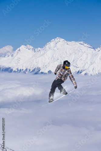 Snowboard rider jumping on mountains. Extreme snowboard freeride sport.