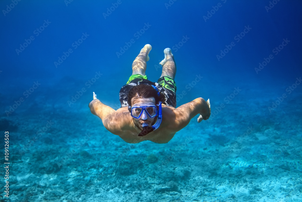 Underwater shoot of a young man snorkeling in a tropical sea - obrazy, fototapety, plakaty 