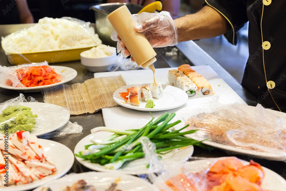 Preparing of sushi rolls with salmon