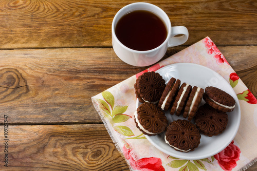 Chocolate cookies sandviches and cup of tea