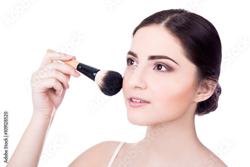 close up portrait of young beautiful woman with make up brush is