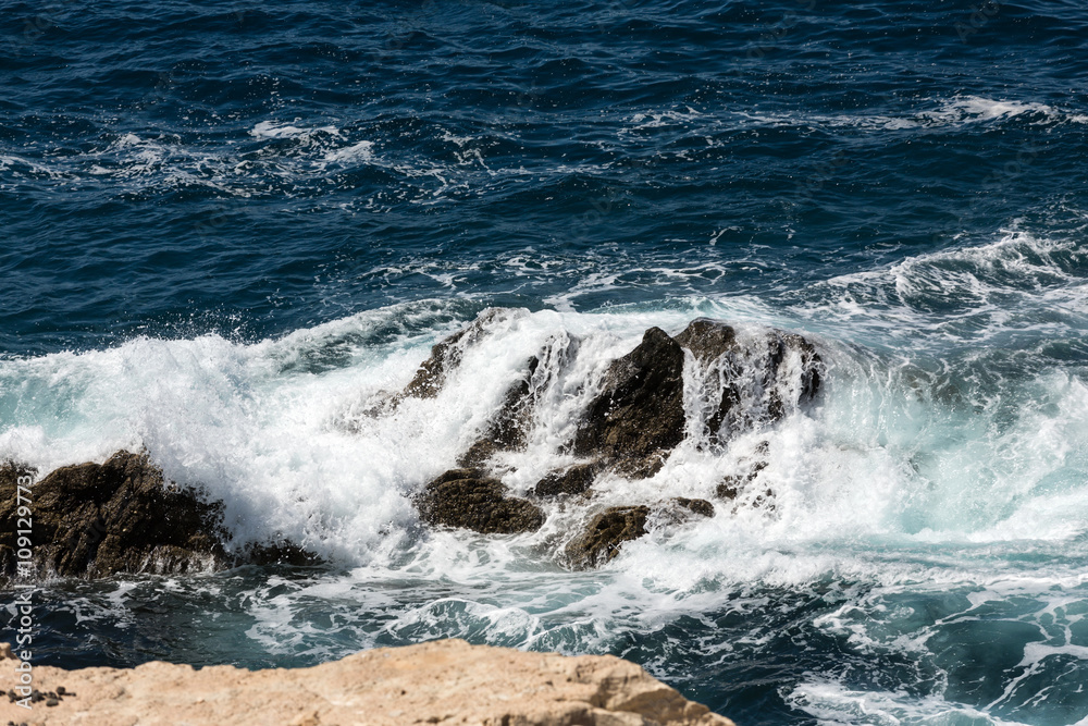 Wave splashing over a rock on Caleta Negra beach in Ajuy on Fuerteventura. Canary Island, Spain Wave splashing over a rock on Caleta Negra beach in Ajuy on Fuerteventura. Canary Island, Spain
