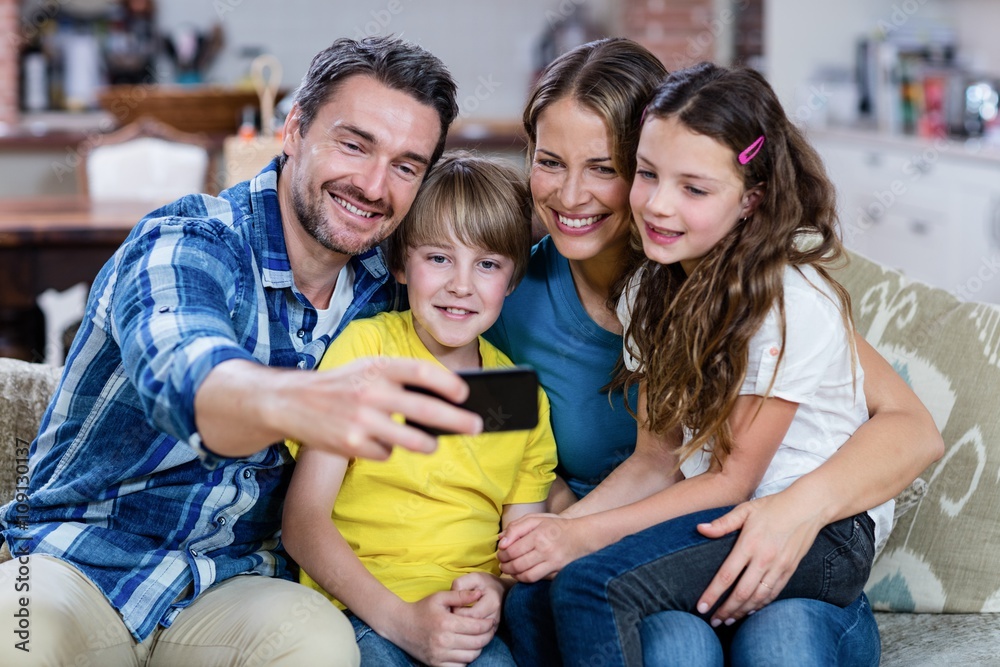 Fototapeta premium Happy family taking a selfie on mobile phone