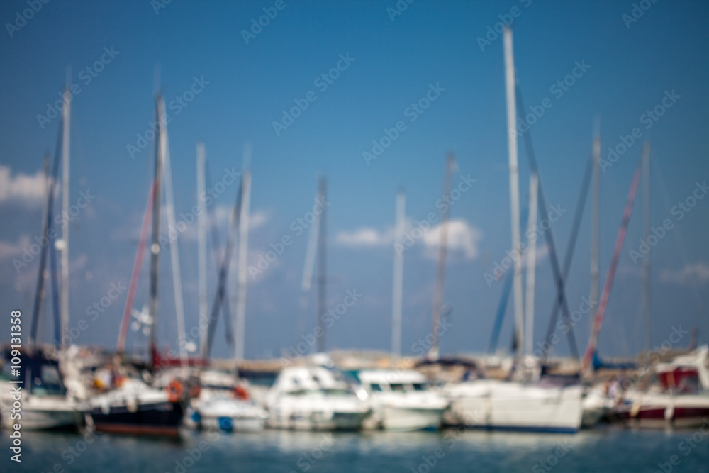Blurred background of a sail yachts harbor at sunset