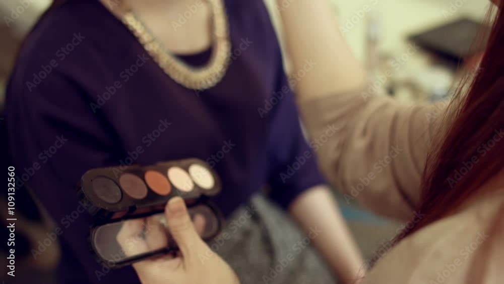 Make-up artist doing professional make-up to the model Make-up artist doing professional make-up to the model