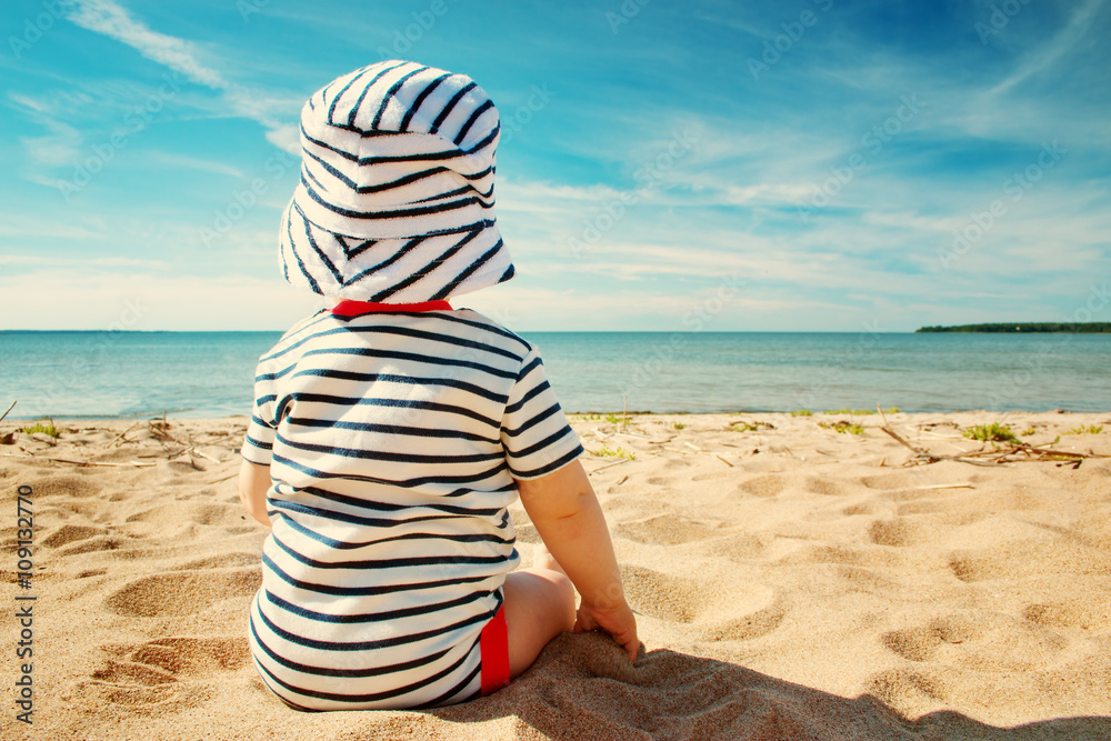 Little baby boy sitting on the beach in summer day Little baby boy sitting on the beach in summer day