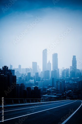  highway against city buildings, blue toned image.