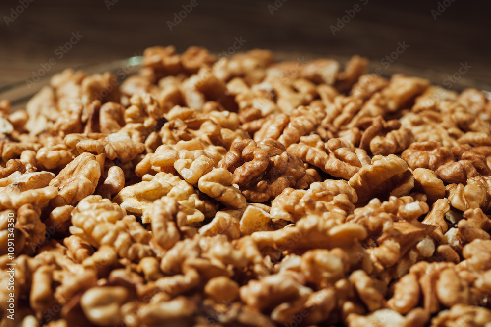 shelled walnuts on a plate, wooden background shelled walnuts on a plate, wooden background