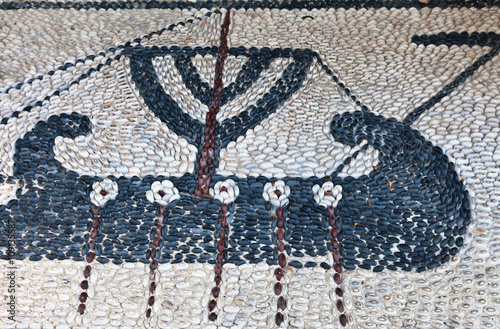 Fototapeta Naklejka Na Ścianę i Meble -  Traditional Greek ornaments of sea pebbles on the streets of the old town of Lindos