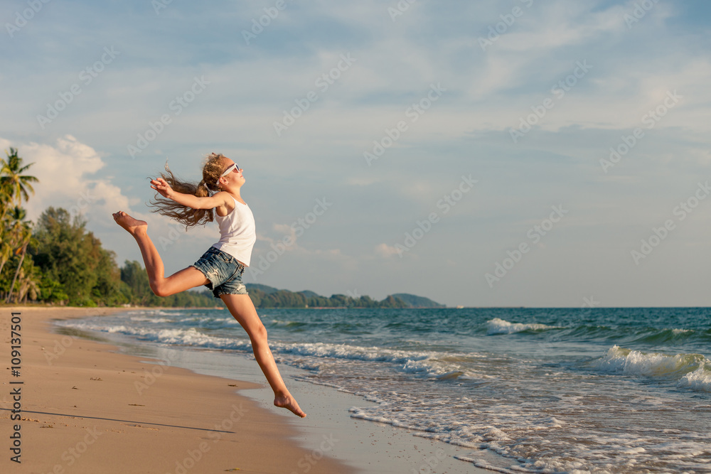 Teen girl jumping on the beach at the day time. Teen girl jumping on the beach at the day time.