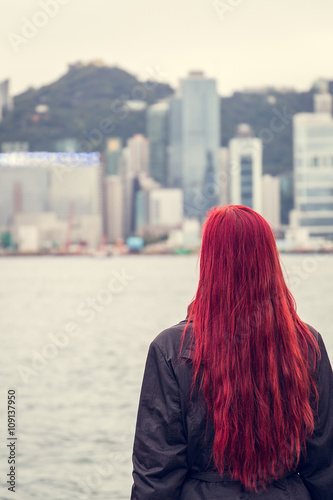 Young Woman with Red Hair looking at the Commercial City of Hong Kong