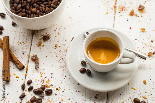 Coffee Cup  Beans  Cinnamon Sticks on White Wooden table