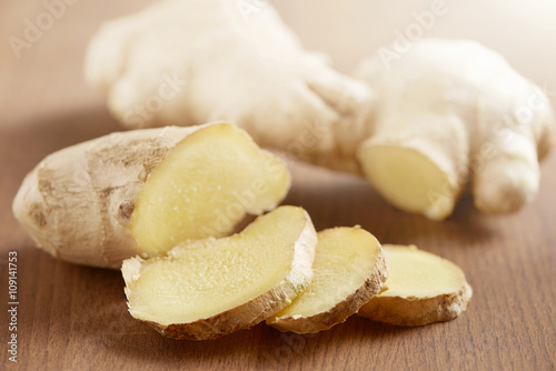 ginger sliced on a wooden cutting board