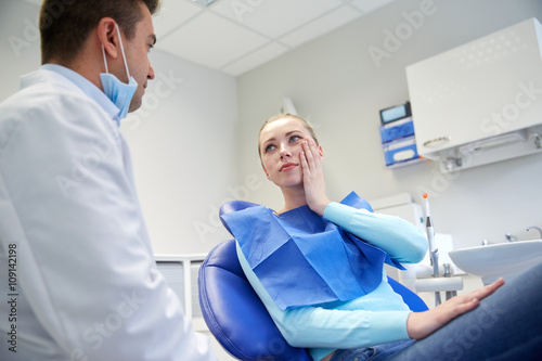male dentist with woman patient at clinic