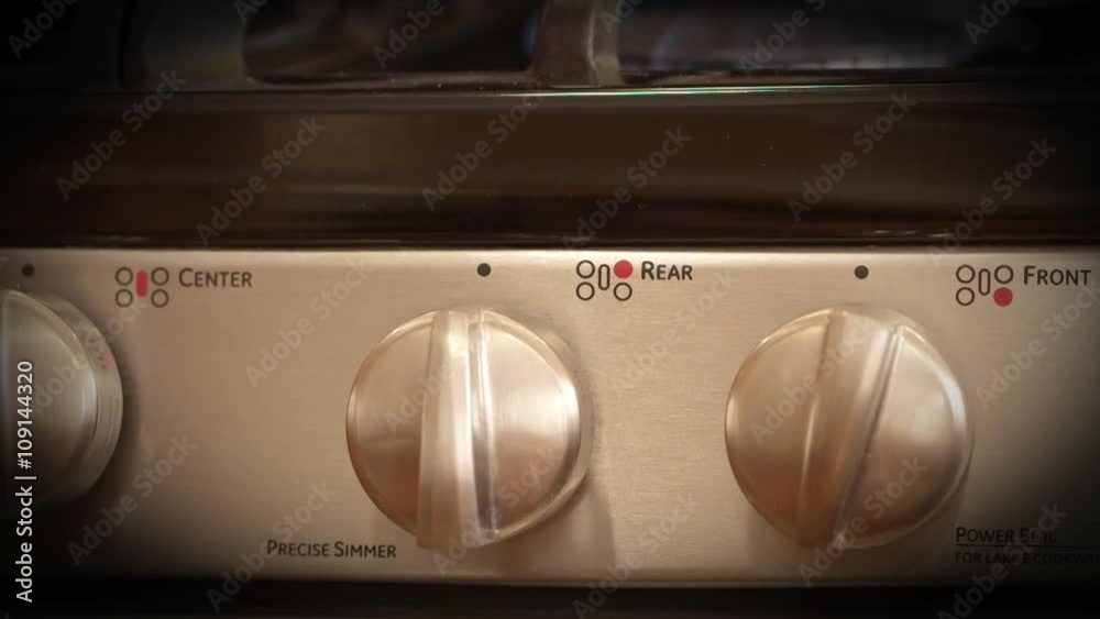 Front view of modern stainless steel gas stove - temperature control knob Front view of modern stainless steel gas stove - temperature control knob