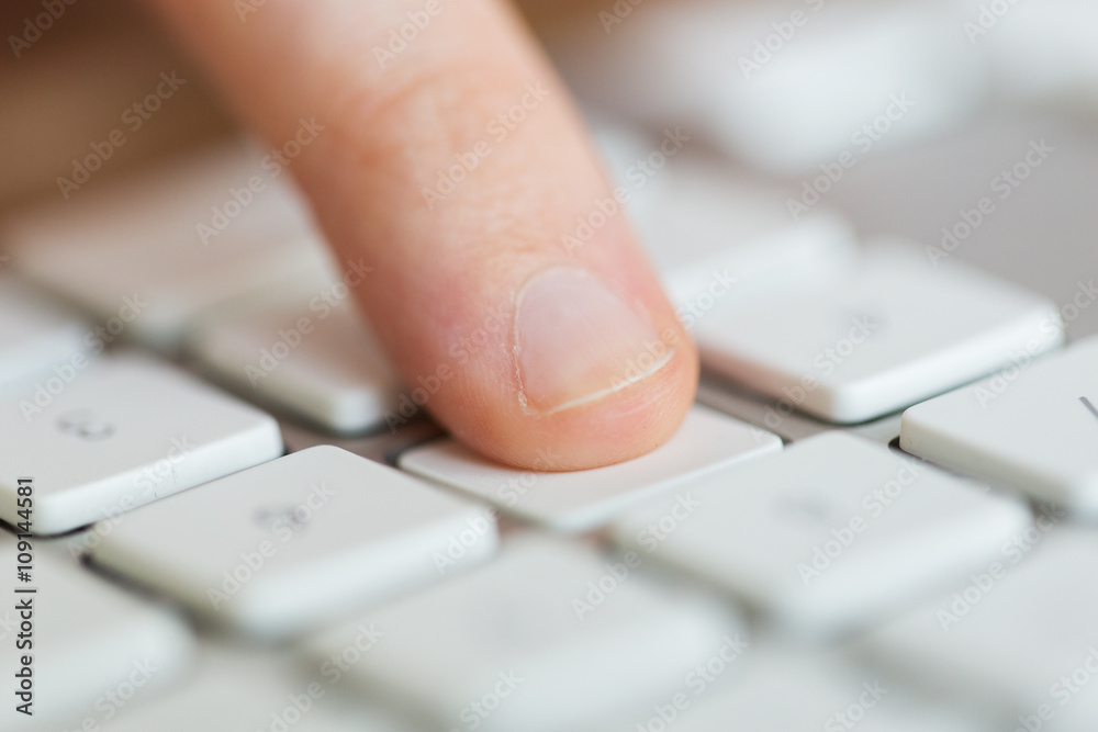 close up of finger pressing button on keyboard close up of finger pressing button on keyboard