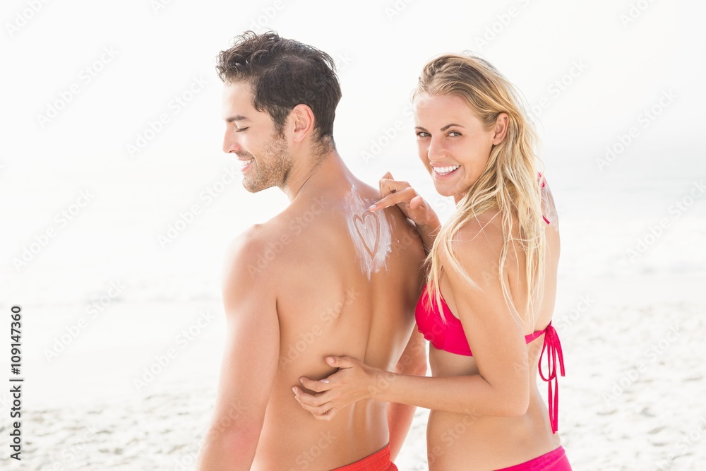 Girlfriend applying sun cream on boyfriend Girlfriend applying sun cream on boyfriend