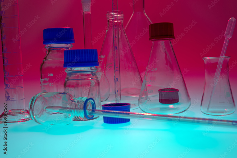 Laboratory equipment against red background on blue table