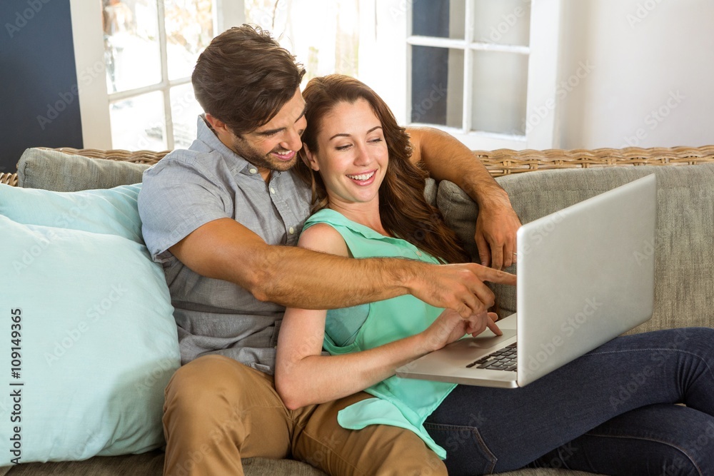 Happy young couple using laptop