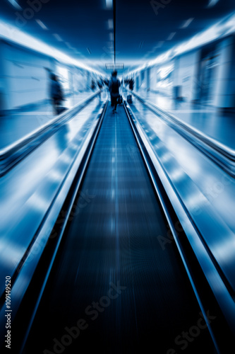 moving walkways at airport,blue toned image.