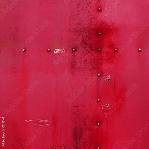 Riveted red metal. Abstract painted matte red metal background texture with rivets. Red metal background.