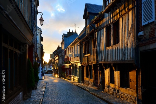 Picturesque street in the Normandy town of Honfleur, France with light of the rising sun