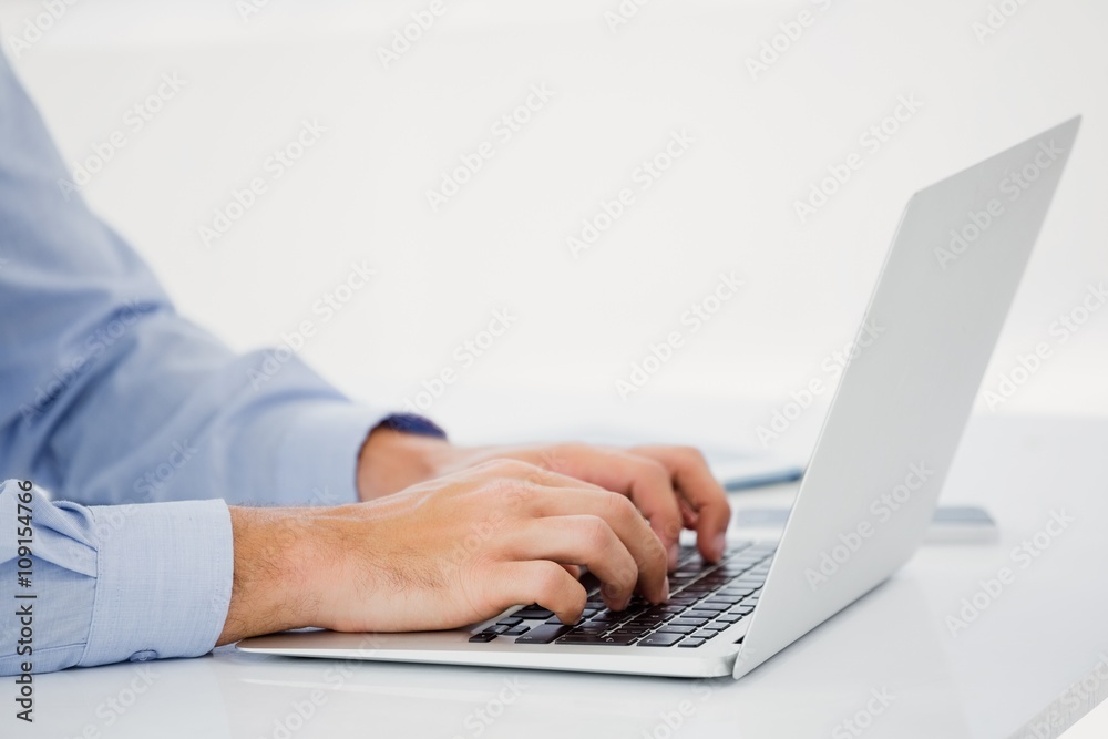 Mid-section of businessman working on laptop Mid-section of businessman working on laptop
