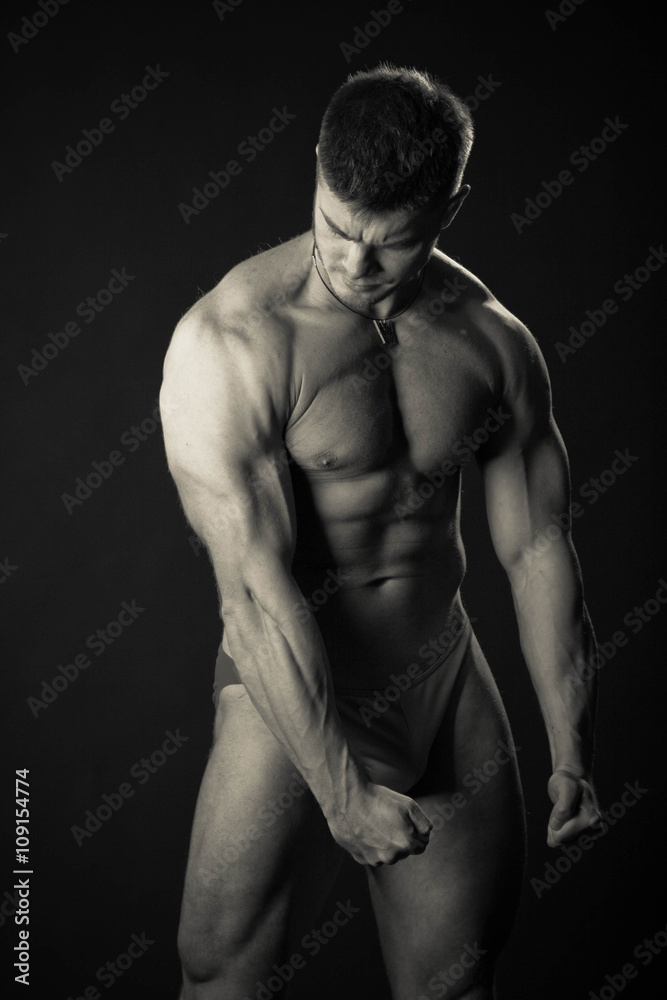 Bodybuilder showing his back and biceps muscles, personal fitness trainer. Strong man flexing his muscles Bodybuilder showing his back and biceps muscles, personal fitness trainer. Strong man flexing his muscles
