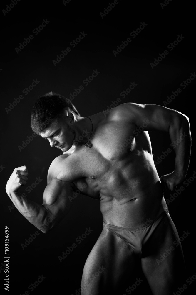 Bodybuilder showing his back and biceps muscles, personal fitness trainer. Strong man flexing his muscles Bodybuilder showing his back and biceps muscles, personal fitness trainer. Strong man flexing his muscles