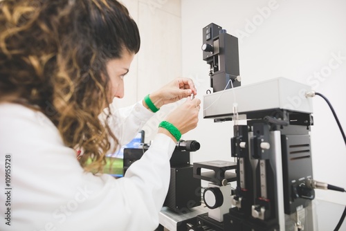 Female scientist looking at contact angle, preparing instrument for drop measurement on a specific substrate