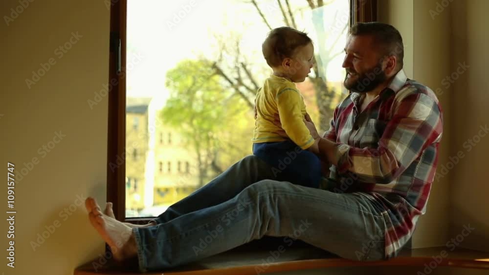 Father with little son are sitting on windowsill
Father with little son are sitting on windowsill
