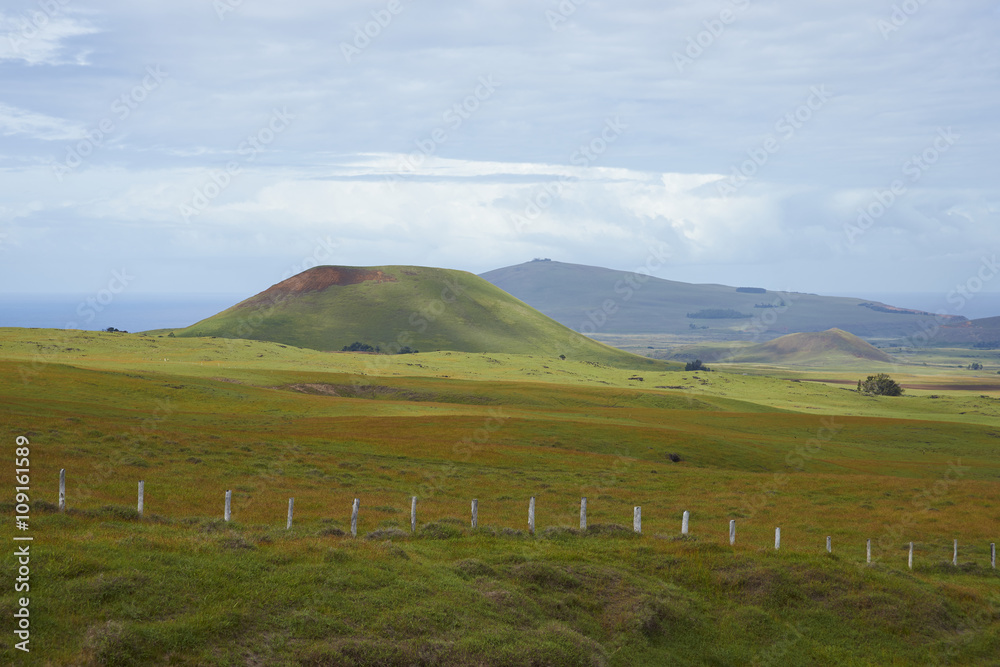 Landscape of Easter Island. Rolling green pasture dotted with the remains of extinct volcanoes.