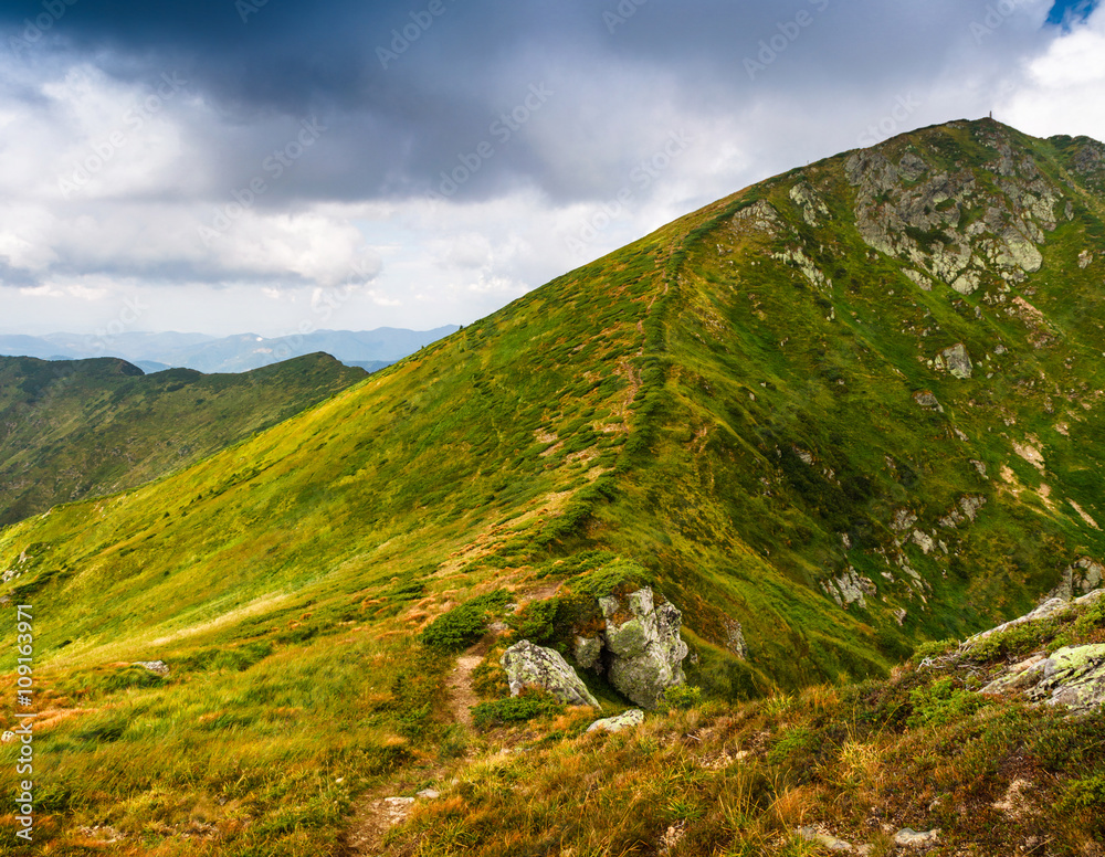 Fototapeta premium View of panoramic mountains landscape of a rocky cliffs and green hills.