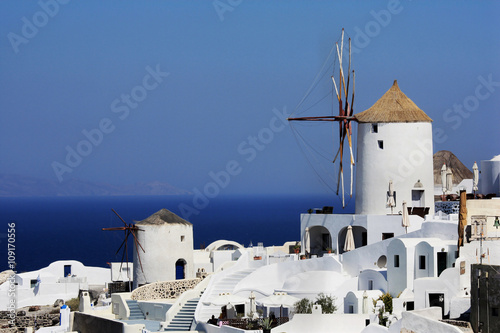 The island Santorini in Greece. Attractive view, white houses and windmill, sea. Sunny day.