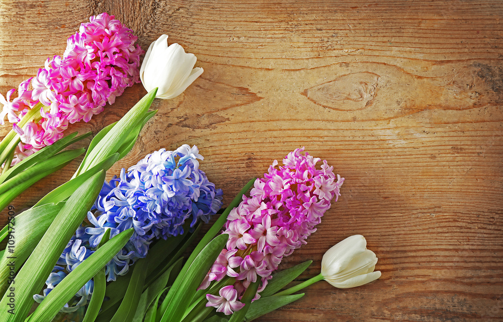 Composition of hyacinth and tulips on wooden background Composition of hyacinth and tulips on wooden background