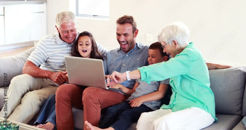 Happy multi generation family using laptop Happy multi generation family using laptop