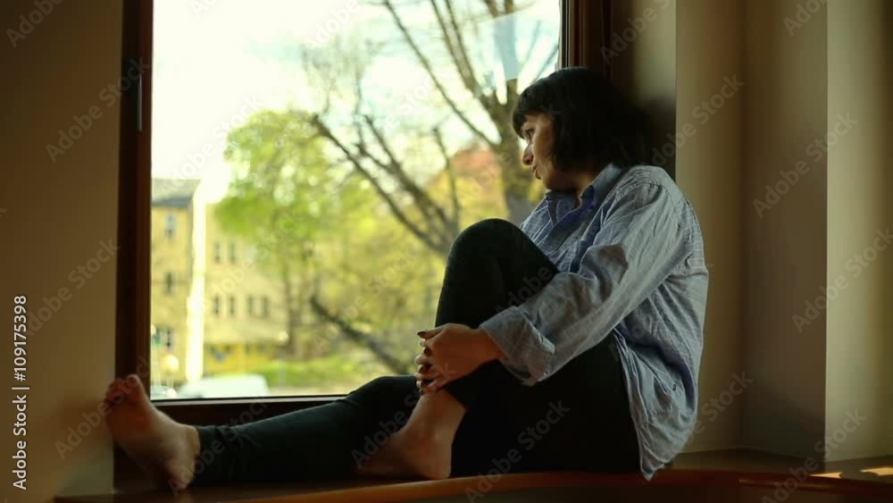 Sad woman sitting near window
Sad woman sitting near window