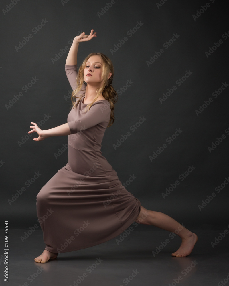 Contemporary dance. Beautiful elegant woman dances on gray background