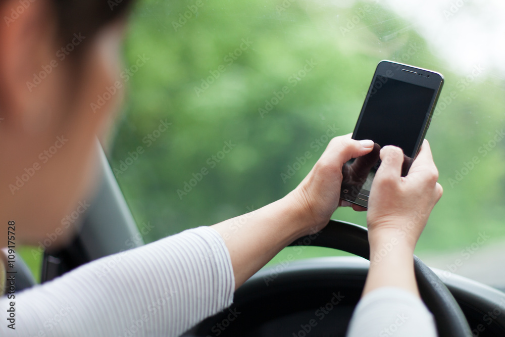 young woman driving and texting