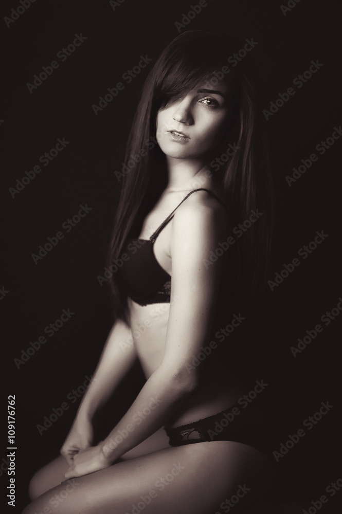 Shot of a sexy woman in black lingerie over black background. Shot of a sexy woman in black lingerie over black background.