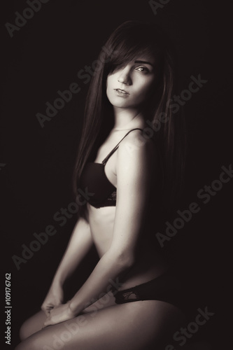 Shot of a sexy woman in black lingerie over black background.